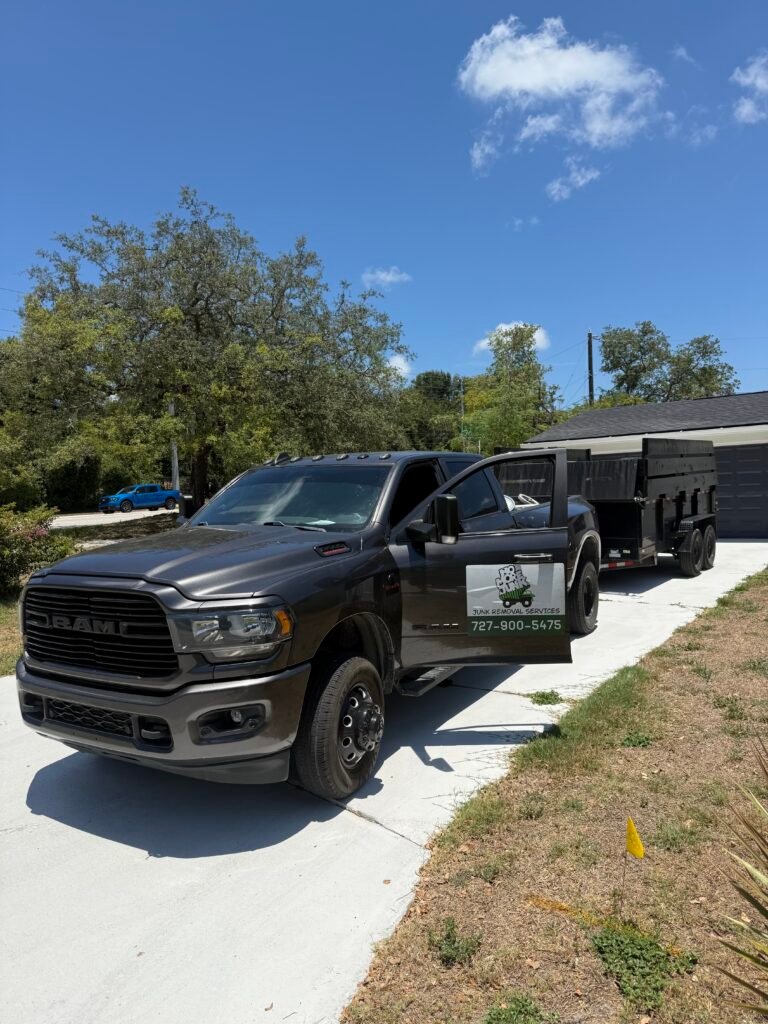 No More Junk branded truck and dump trailer parked at a residential junk removal project in Clearwater, FL.