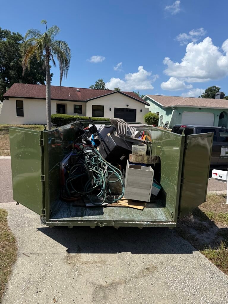 No More Junk construction debris removal service in Palm Harbor, FL with a dump trailer loaded for disposal.