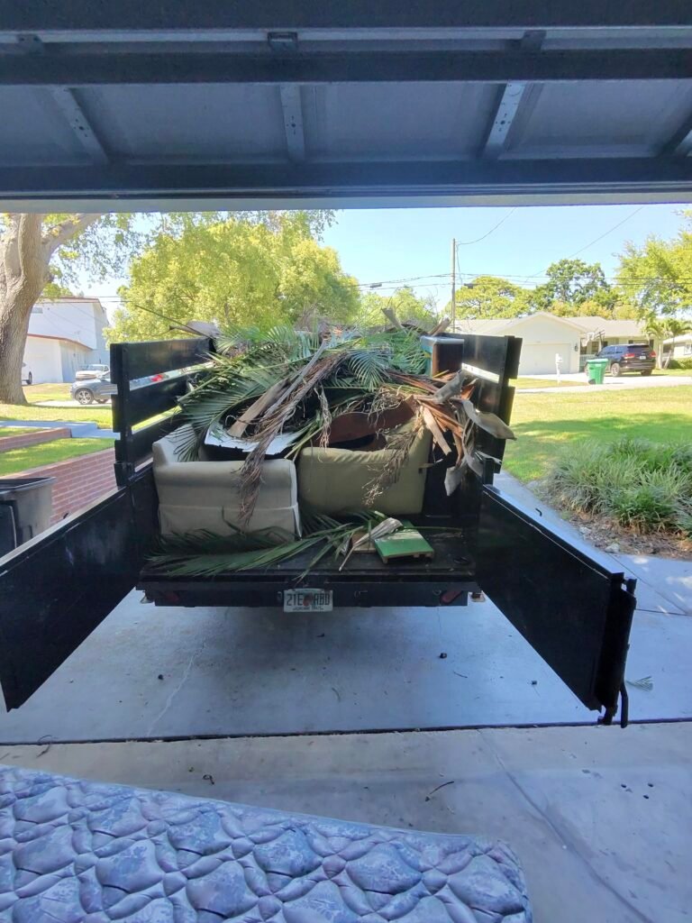 Dump trailer fully loaded with household junk after a completed residential cleanout for a homeowner in Palm Harbor, Florida.