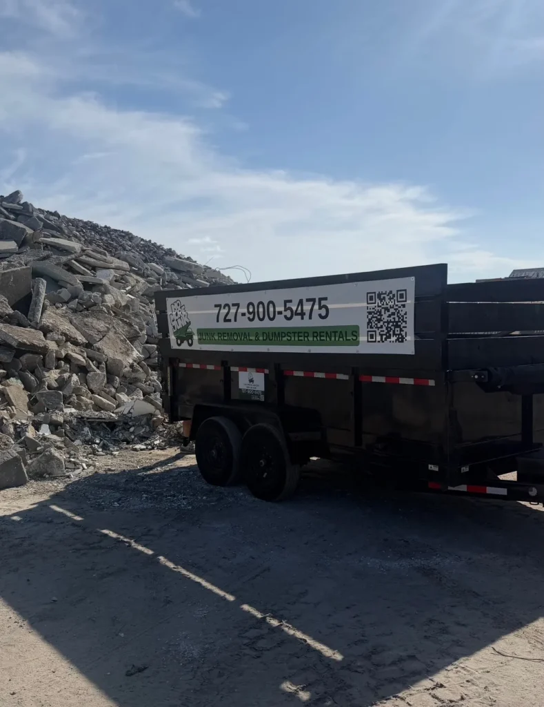 No More Junk branded dump trailer beside a pile of construction debris