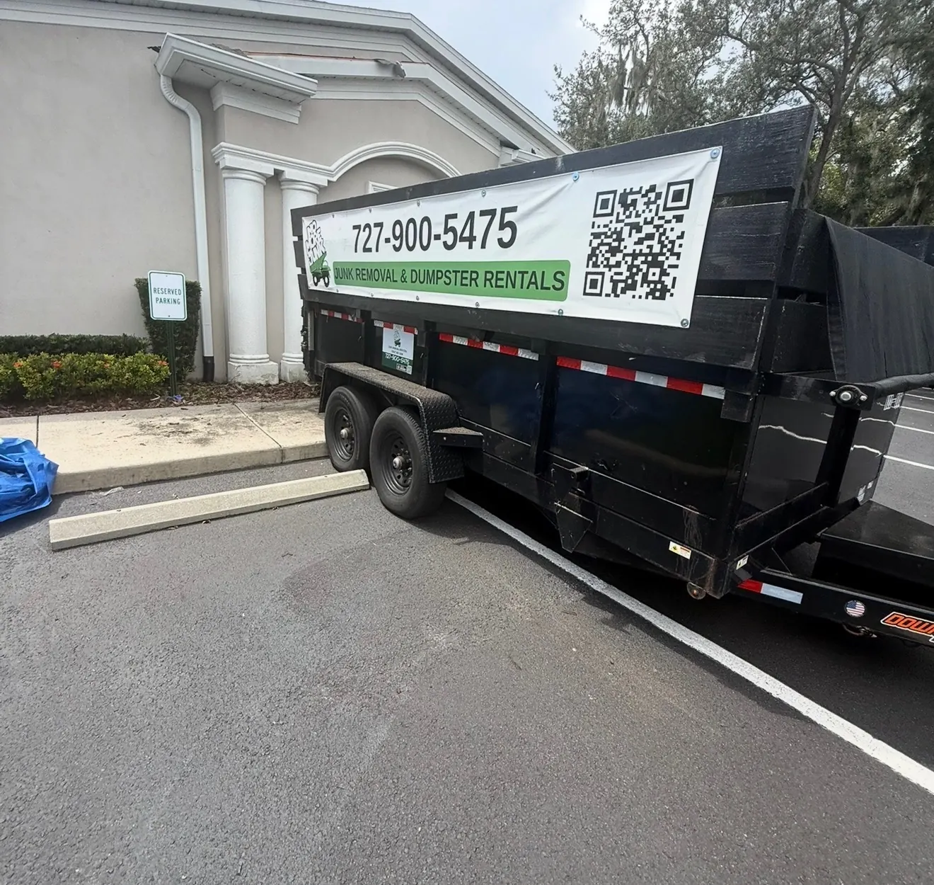No More Junk dump trailer parked beside a building